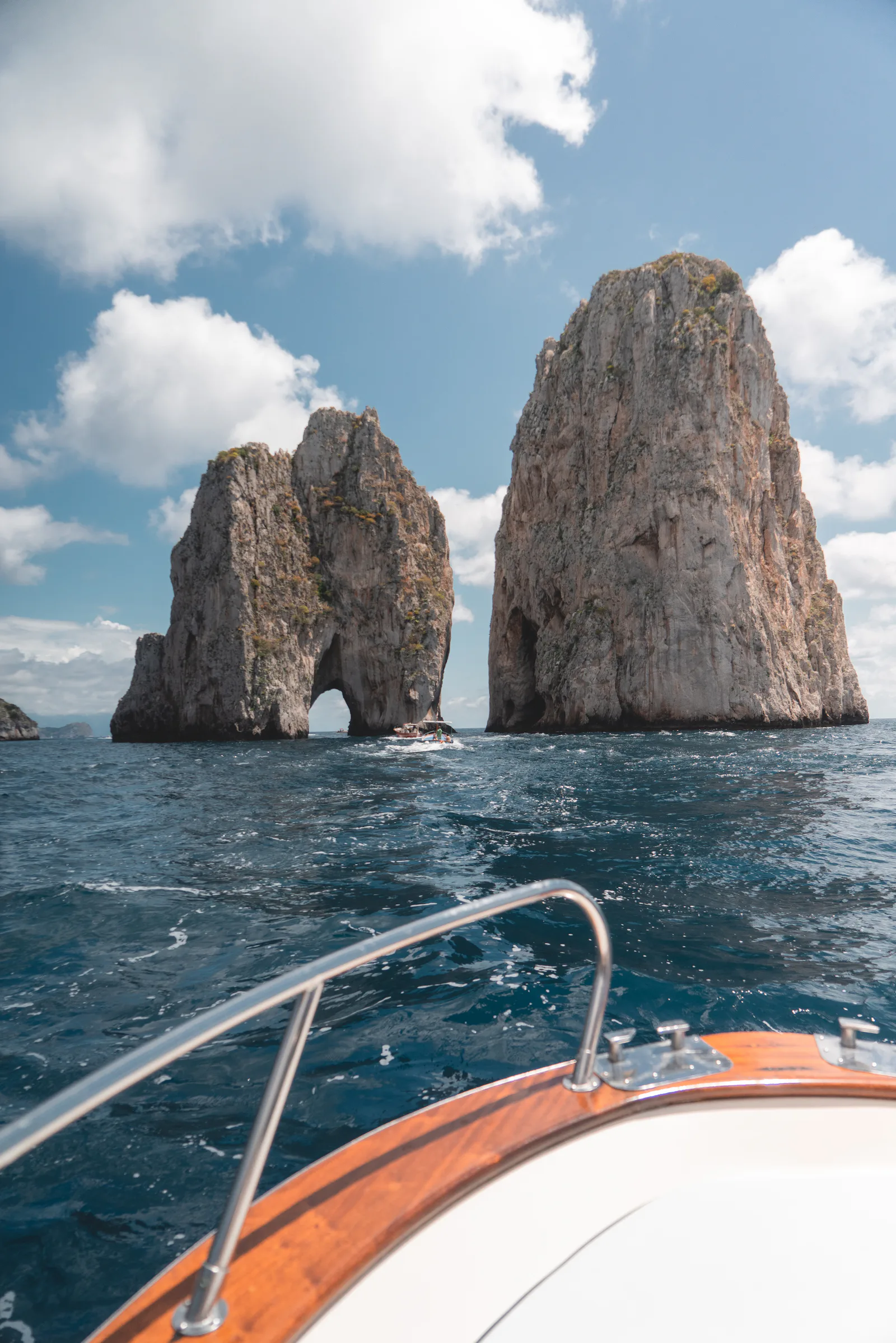 A boat sailing towards the Faraglioni of Capri